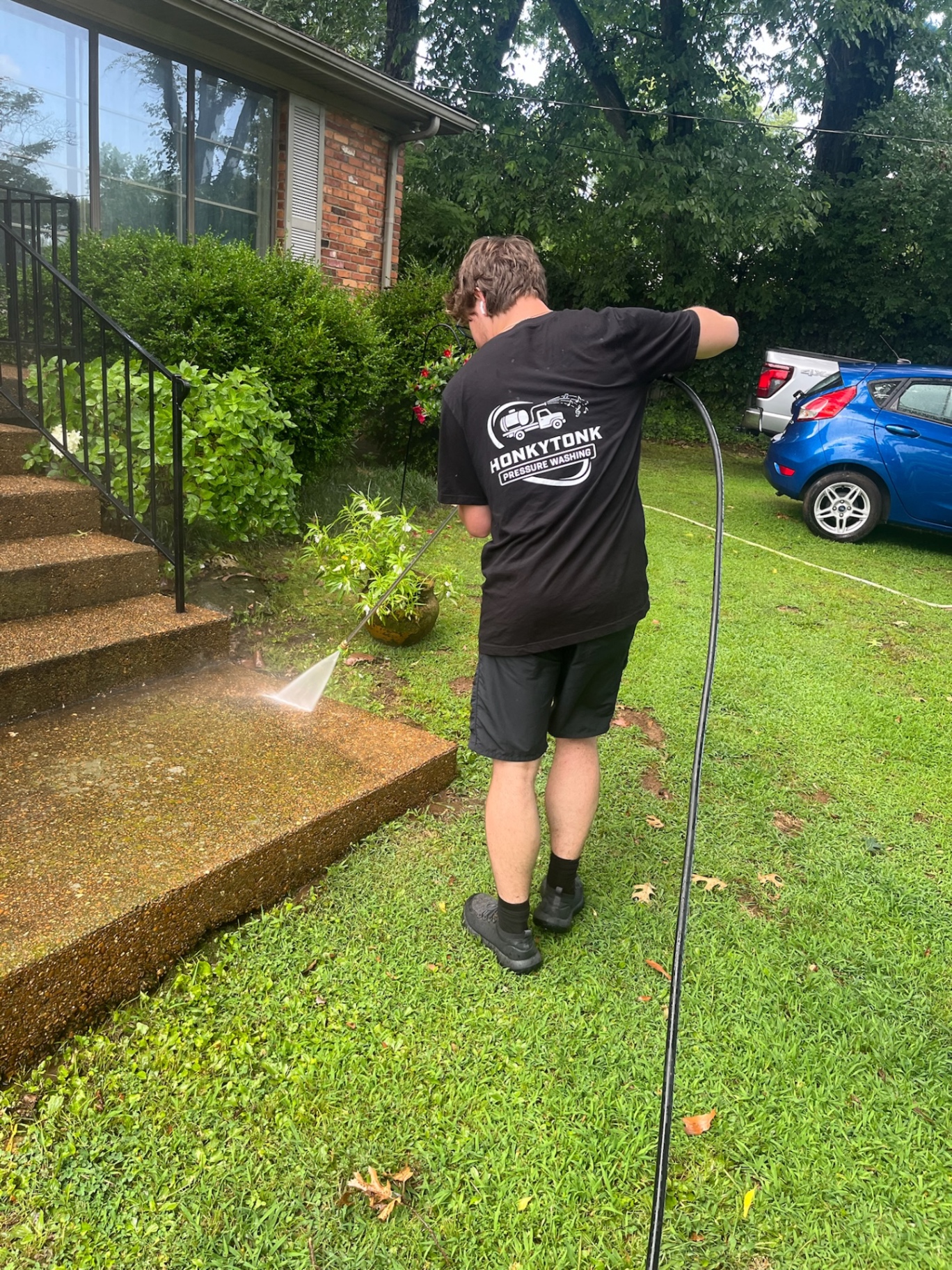 Honky Tonk Pressure Washing team member cleaning aggregate concrete steps at a Nashville, TN home